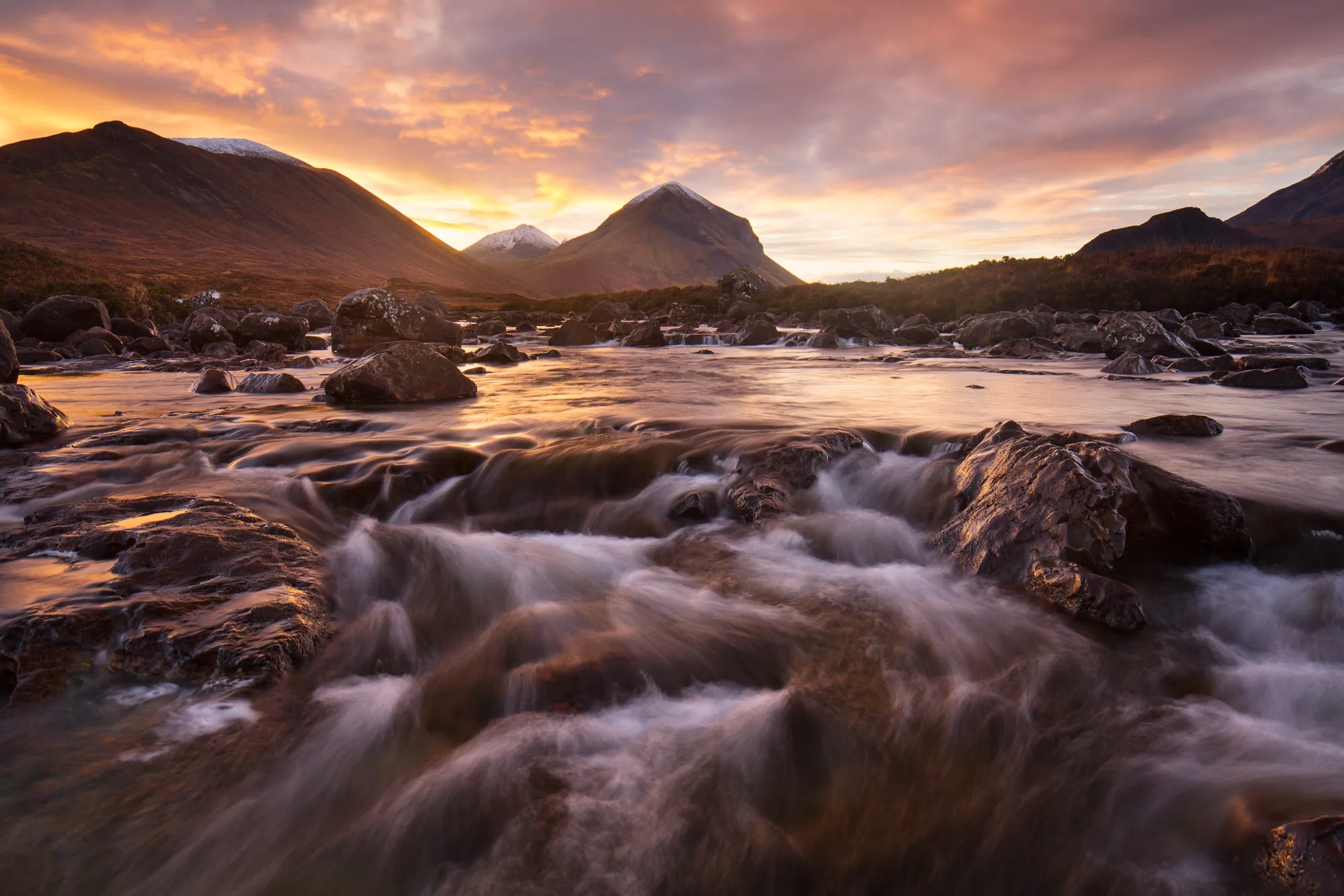 Sligachan river and snow capped mountains at sunrise, moody sky long exposure landscape photography scotland