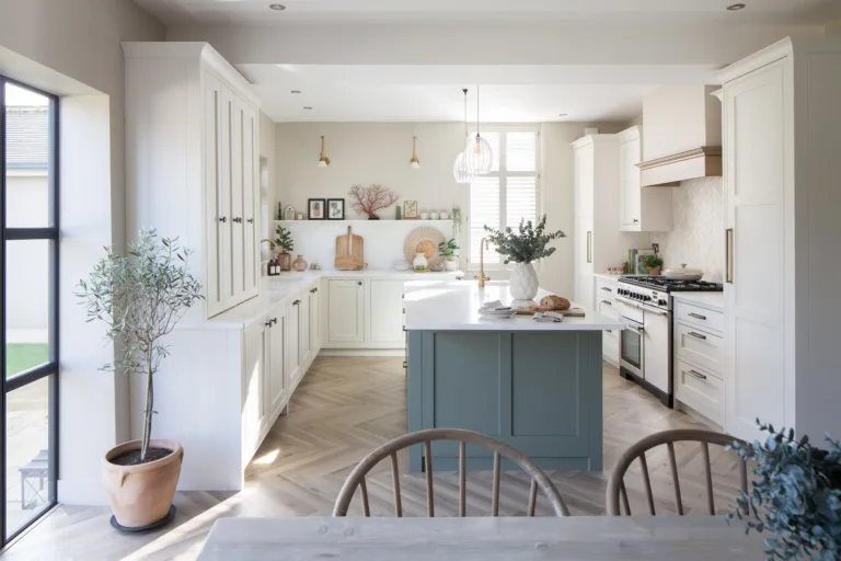 Photograph of kitchen installation for interior designer. Light painted shaker units with soft green island, black aluminium crittal doors